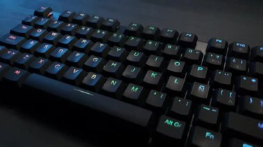 Gri ahşap bir masada rgb ışıklandırmalı mekanik klavye