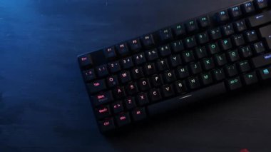 Gri ahşap bir masada rgb ışıklandırmalı mekanik klavye