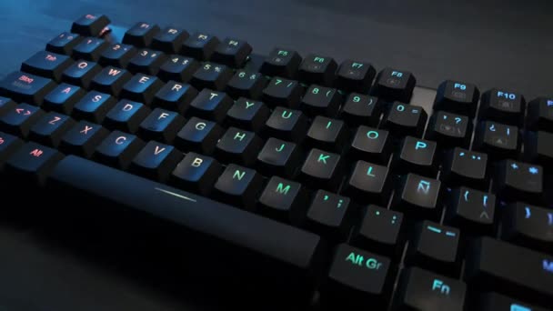 Mechanisch toetsenbord met rgb verlichting op een grijs houten bureau — Stockvideo
