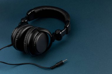 Mavi arkaplan ve metin için yeri olan siyah kulaklıklar