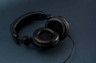 Mavi arkaplan ve metin için yeri olan siyah kulaklıklar