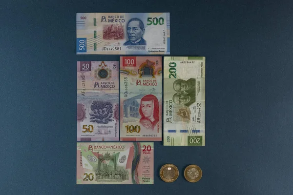 Nieuwe Mexicaanse peso biljetten en munten, gerangschikt op een blauwe achtergrond met ruimte voor tekst — Stockfoto