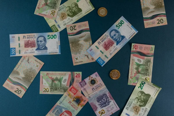 Τραπεζογραμμάτια διαφορετικών ονομαστικών αξιών του μεξικανικού νομίσματος, διασκορπισμένα σε μπλε σουπερφίτσα — Φωτογραφία Αρχείου