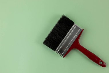 Siyah tüylü kırmızı bir fırçanın yeşil arkaplan ve metin için boşluk üzerindeki üst görünümü