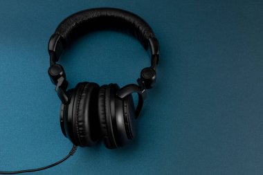 Mavi arkaplan ve metin için yeri olan siyah kulaklıklar