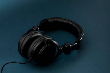 Mavi arkaplan ve metin için yeri olan siyah kulaklıklar