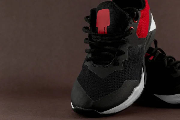 Fekete és piros sportcipő barna alapon, szöveges szöveggel — Stock Fotó