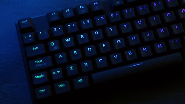 Panoramique mécanique du clavier avec éclairage RVB sur un bureau — Video