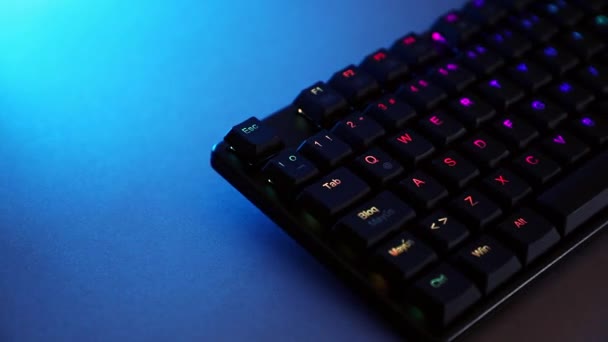 Mechanical keyboard on desk with blue lighting — Stockvideo