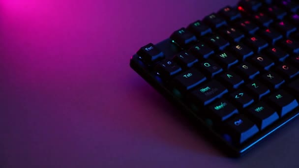 Mechanical keyboard on desk with purple lighting — стоковое видео