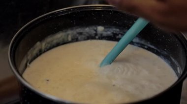 move with a spoon the rice pudding that is in a pot, homemade