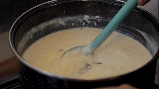 Move with a spoon the rice pudding that is in a pot, homemade — Stock video