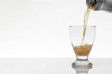 Serving a can of beer in a crystal glass with a white background and copy space
