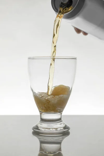 Servera en burk öl i ett kristallglas med en vit bakgrund — Stockfoto