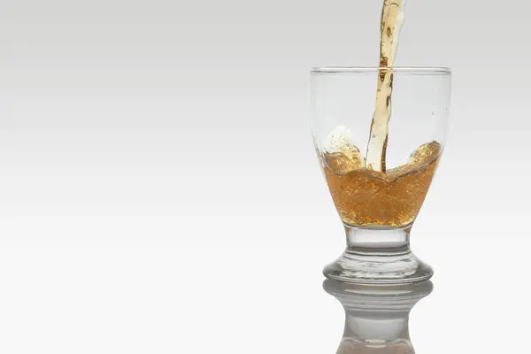 Pouring beer into a crystal glass, movement of beer into the glass, with copy space — ストック写真