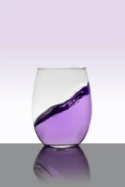 Lila Getränk im Glas mit einem Spritzer und weißem Hintergrund — Stockfoto