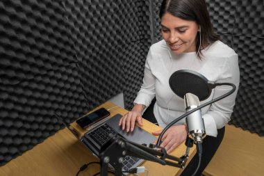 Ses kabininde podcast kaydeden bir kadının üst görüntüsü