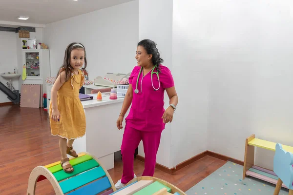 Mädchen läuft in Kinderarztpraxis auf einem Holzspiel — Stockfoto