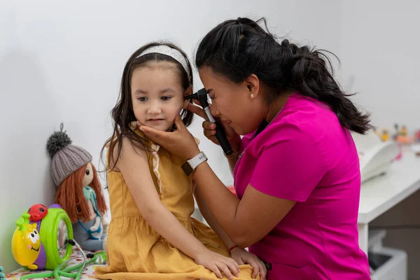 女性小児科医師チェックA女の子耳とともにA Otoscopy — ストック写真
