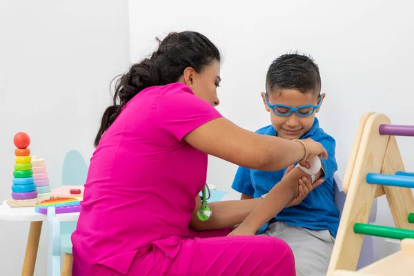 Latina Kinderarts Meten Van Een Kinderarm Haar Kantoor — Stockfoto