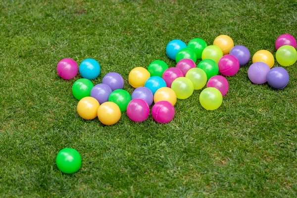 庭の芝生の上で投げられる子供たちのための色のボール — ストック写真