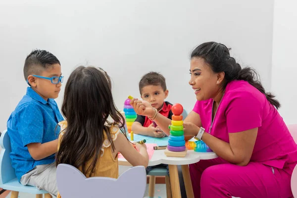 Female Pediatrician Sitting Table Several Children Playing Her Medical Office — ストック写真