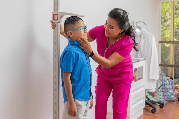 Pediatric Female Doctor Holding Childs Head While Measuring Floor Ruler — Stockfoto