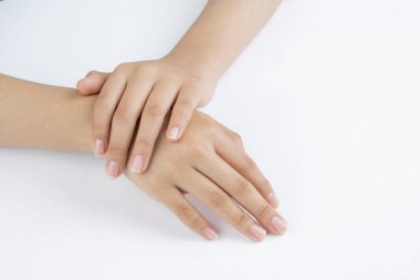 Genç bir kadının elleri, el ve tırnak bakımı, beyaz arka plan ve kopyalama alanı..