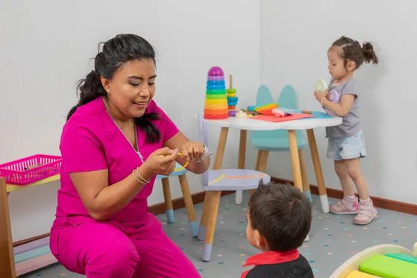 Latin Pediatrician Playing Child Her Medical Office While Girl Plays — ストック写真