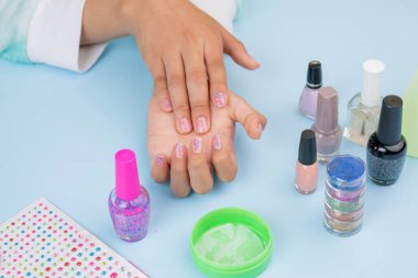 girls hands, showing nails after painting them, with copy space.