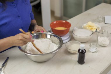 Kadınlar evde ekmek yapmak için unu malzemelerle karıştırır.