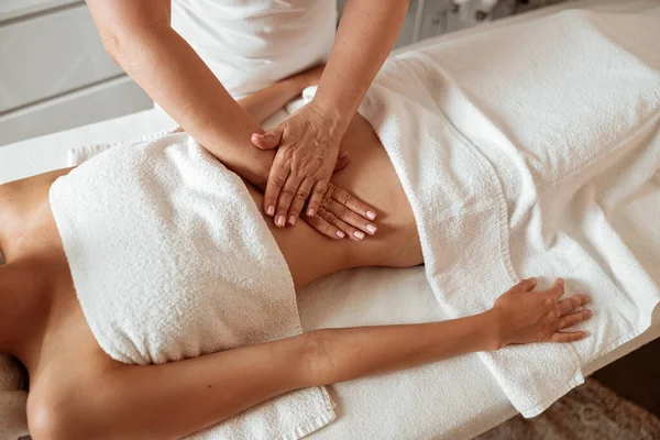 Mujer joven recibiendo masaje abdominal en el salón de spa —  Fotos de Stock