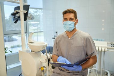 Diş sağlığı kliniğinin arkadaş canlısı personeli hasta listesi ile poz veriyor