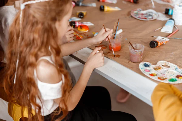 Κοκκινομάλλα Κορίτσι Κάθεται Στο Τραπέζι Ενώ Σχέδιο Ακουαρέλα Στην Τάξη — Φωτογραφία Αρχείου