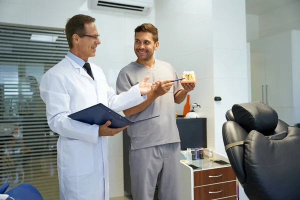 İki erkek diş hekimi klinikte profesyonel bir konuşma yapıyor. — Stok fotoğraf