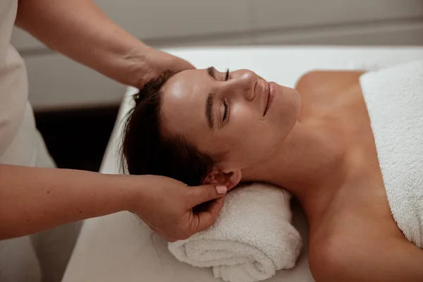 Encantadora joven recibiendo masaje profesional en el salón de spa —  Fotos de Stock