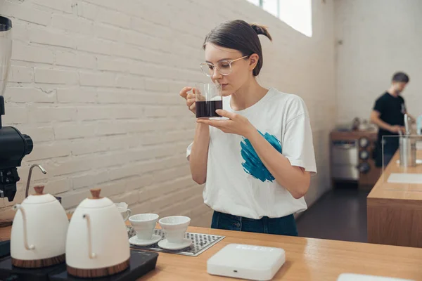 Encantadora camarera hembra oliendo café en la cafetería —  Fotos de Stock