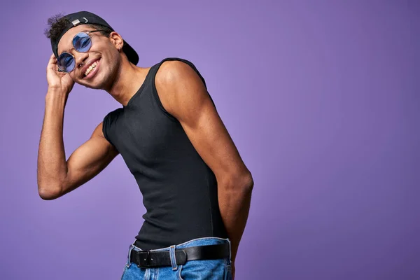Smiling transgender male in black t-shirt with hand on cap portrait. Young sportsman in casual dress — Stock Photo, Image