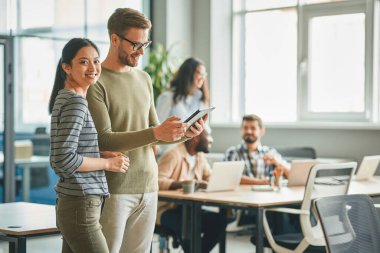 Yoğun bir ofiste yan yana duran iki meslektaş