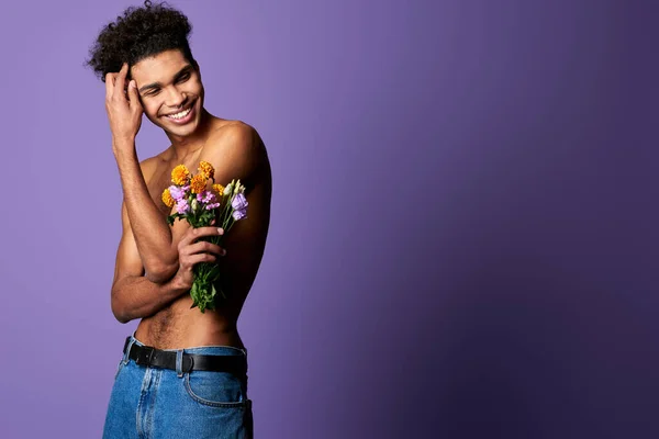 Retrato de homem transexual sorridente com flores. Esportista atlético sensível com corpo perfeito — Fotografia de Stock