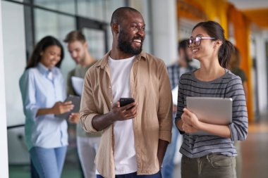 İşçiler koridorda yeni projeleri tartışıyorlar.