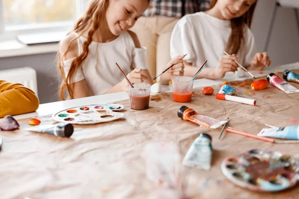 Estudantes sorrindo fazendo pintura de arte usando cores da água — Fotografia de Stock