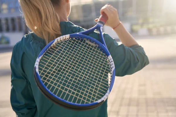 Primer plano de raqueta de tenis en las manos de la mujer deportiva, jugador de tenis profesional de pie al aire libre, listo para el entrenamiento de la mañana —  Fotos de Stock