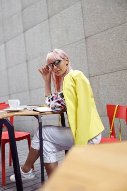 Dişi, bardakları dışarıda ayarlarken kameraya dönüyor.