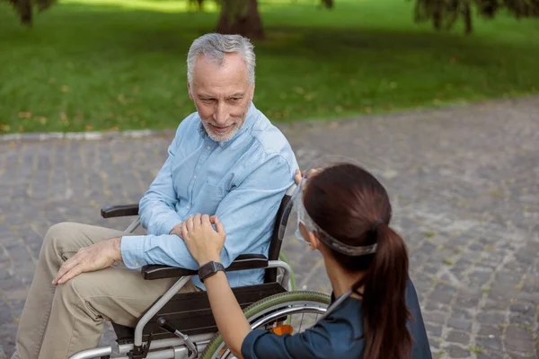 Senior orang tua, pemulihan pasien di kursi roda Menatap dan memegang tangan perawat Memakai wajah perisai dan topeng, mendukung dia — Stok Foto