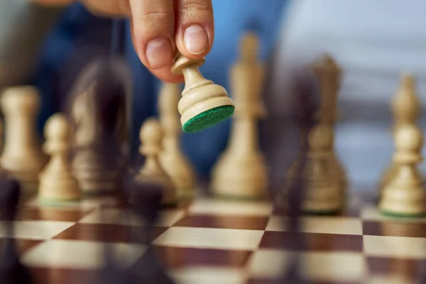Крупный план женской руки, перемещающей шахматные фигуры во время игры в шахматы — стоковое фото