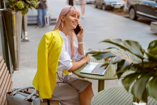 Wanita ceria memiliki percakapan telepon di kafe outdoor — Stok Foto