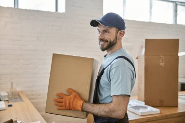 Eldivenli neşeli sakallı adam elinde karton kutu