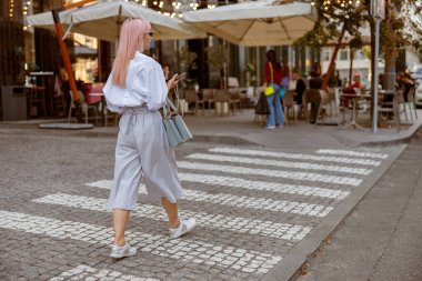 Caddeden karşıya geçen genç bir kadın.