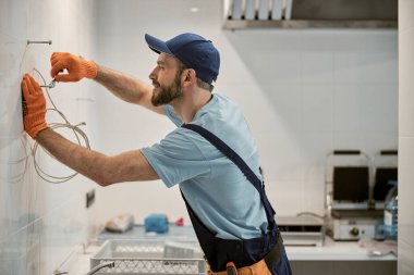 İngiliz anahtarıyla cıvata çeviren neşeli erkek işçi